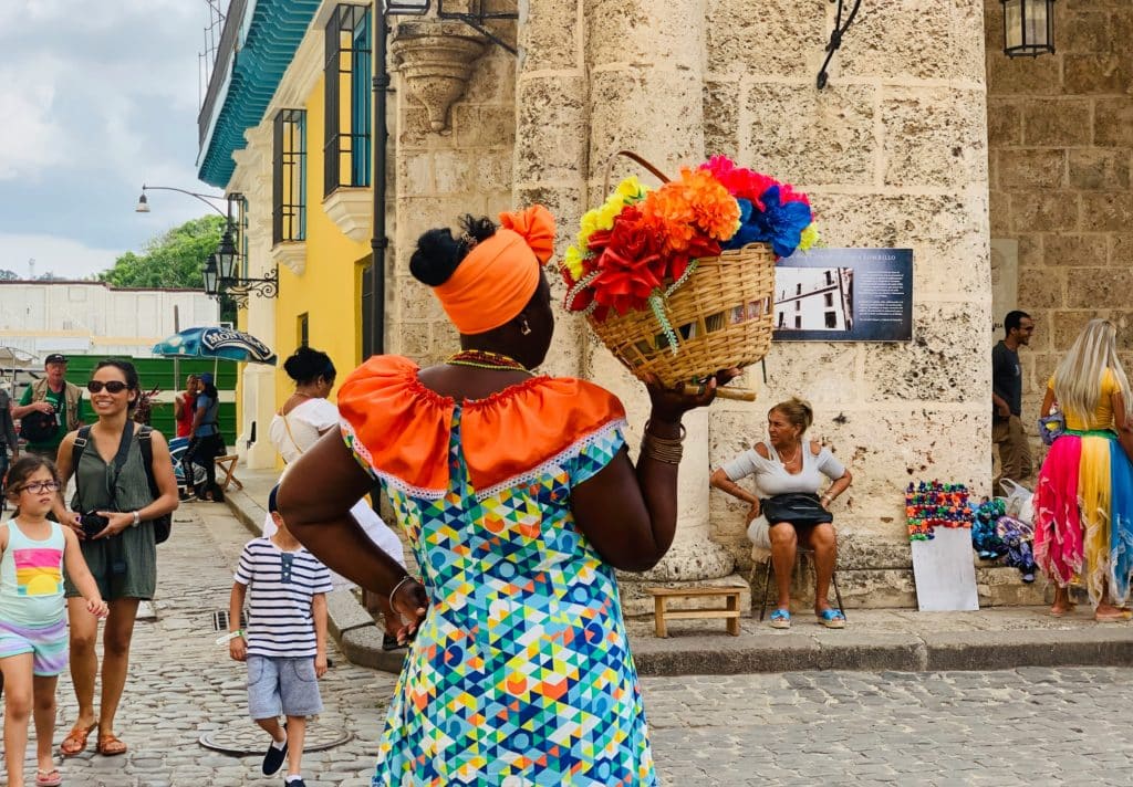 žena u šarenom s košarom cvijeća na ulicama havane