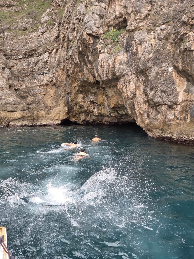 tourists swimming in Adriatic sea near hidden cave on Dubrovnik boat tour cliff jumping experience Croatia