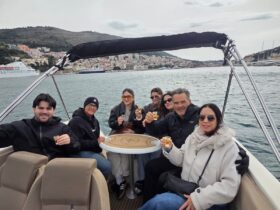 Group enjoying Elaphiti Islands private boat tour in Dubrovnik with drinks onboard luxury speedboat Adriatic coastline Croatia