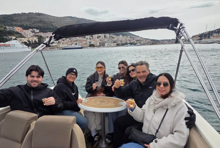 Group enjoying Elaphiti Islands private boat tour in Dubrovnik with drinks onboard luxury speedboat Adriatic coastline Croatia